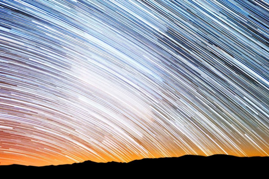 Star trails over mountains